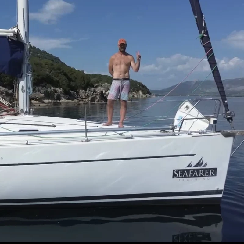 John Hanusek on the bow of a sailboat